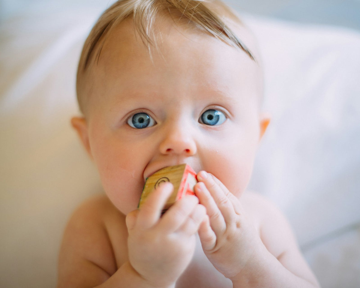 Baby reaching for a wooden block
